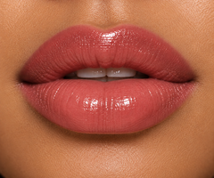 JJ Luxe Cosmetics Slow Burn Sheer Peptide Glaze on medium complexion lips in a glossy dusty rose-mauve shade