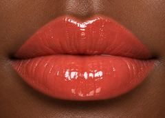 JJ Luxe Cosmetics Heatwave Sheer Peptide Glaze on deep complexion lips in a glossy sheer coral shade