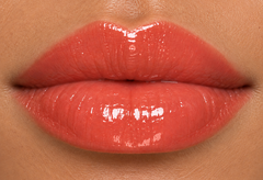 JJ Luxe Cosmetics Heatwave Sheer Peptide Glaze on medium complexion lips in a glossy sheer coral shade