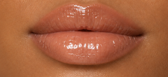 JJ Luxe Cosmetics Last Light Peptide Lip Glaze on deep tan complexion lips in a glossy sheer nude finish.