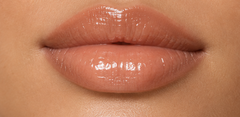 JJ Luxe Cosmetics Last Light Peptide Lip Glaze on light medium complexion lips in a glossy sheer nude finish.