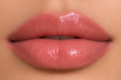 Fair complexion close-up lips wearing JJ Luxe Moonlit sheer blush pink Peptide Lip Glaze with a glossy non-shimmer finish