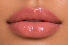 Medium warm olive complexion close-up lips wearing JJ Luxe Moonlit sheer blush pink Peptide Lip Glaze with a glossy non-shimmer finish