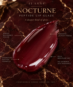JJ Luxe Nocturne Peptide Lip Glaze sheer deep burgundy red-plum texture swatch with a smooth glassy non-shimmer finish on burgundy marble with gold accents.