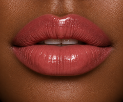 JJ Luxe Cosmetics Slow Burn Sheer Peptide Glaze on deep complexion lips in a glossy dusty rose-mauve shade