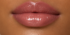 JJ Luxe Cosmetics Slow Burn Peptide Lip Glaze on deep tan complexion lips in a glossy dusty rose-mauve finish.