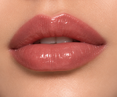 JJ Luxe Cosmetics Slow Burn Sheer Peptide Glaze on fair complexion lips in a glossy dusty rose shade